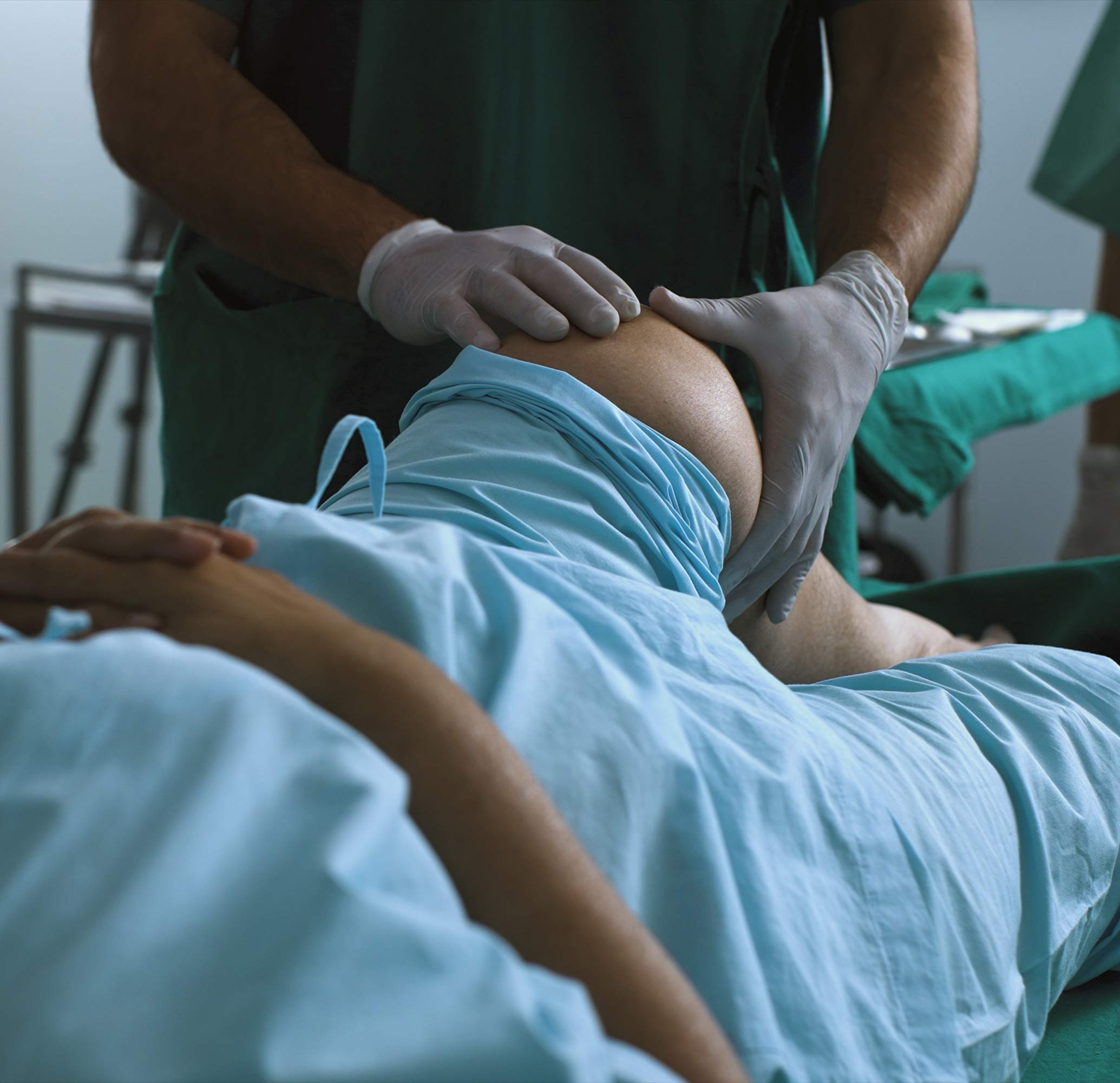 Examen du genou d&rsquo;un patient allong&eacute; par un professionnel de sant&eacute;