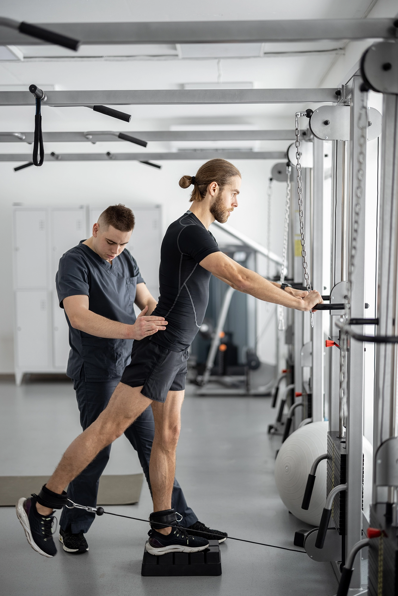 Exercice de r&eacute;&eacute;ducation musculaire avec kin&eacute;sith&eacute;rapeute sur appareil de renforcement